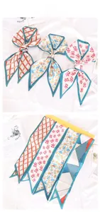 Detailed view of floral satin twilly scarves with geometric prints for hair and bags