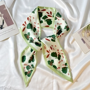 Détail d'un ruban en satin à imprimé floral montrant des motifs de feuilles et de fleurs