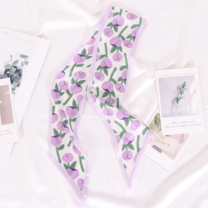 Gros plan du motif tulipe violette sur un foulard fin en soie aux bords soignés