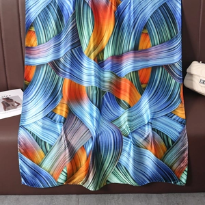 Detail view of the colorful abstract ribbon print and smooth satin texture on the scarf