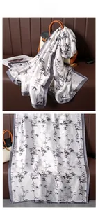 Detail of silk satin scarf showing bamboo leaf print and hand-rolled dark grey edges