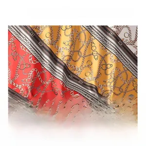 Detailed fabric display of silk-like scarf with vintage gold chain and belt print patterns
