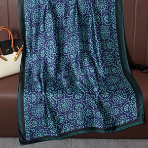 Detailed texture of a vintage silk scarf with floral patterns on a leather sofa