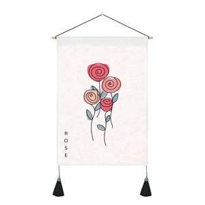 Detail of vintage rose wall tapestry with wooden rod and black tassels on white fabric