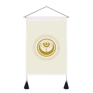 Close-up of sun and moon tapestry featuring golden mystic eye design and black tassels