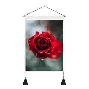 Detalle de lienzo de rosa roja con marco de madera y elegantes borlas negras