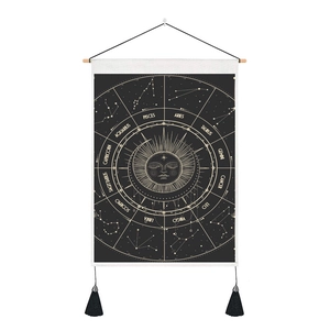 Detail of black tarot tapestry with golden sun and zodiac constellations and tassels