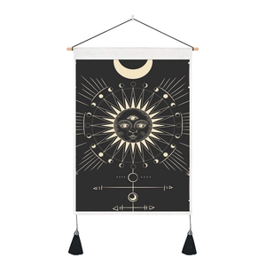 Detail of tarot tapestry showing moon and sun symbols on black canvas with tassels