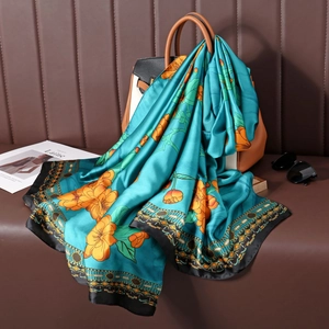 Gros plan d'un foulard en soie fleurie drapé sur un sac en cuir au style élégant