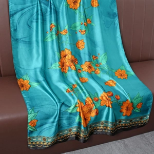Détail d'une écharpe en soie bleu sarcelle avec imprimés floraux oranges et bordures