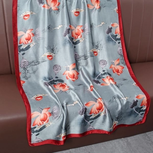 Détail d'un foulard en soie bleu-gris avec motifs lotus rouges et bordures en satin