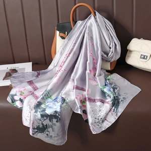 Détail d'un foulard en soie à imprimé lotus drapé sur un sac à main en cuir chic