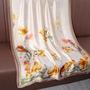 Vue détaillée de l'écharpe en soie champagne avec imprimé floral et bordure satin