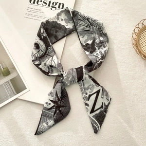 Detailed view of long twilly silk scarf featuring artistic Z letters and star patterns