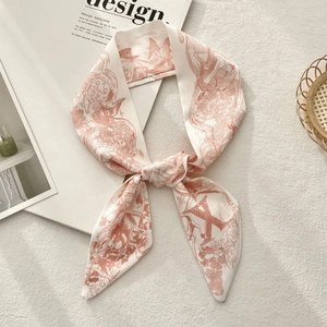 Close-up of a knotted floral twilly scarf with retro illustrations on white carpet