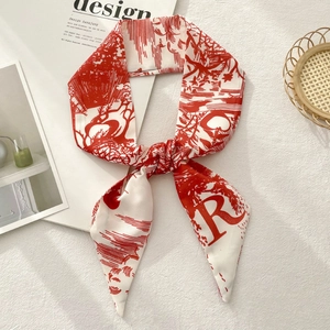 Detail of red and white printed twilly scarf featuring floral patterns and R letter