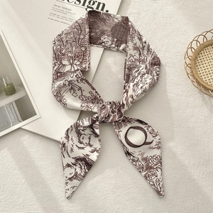 Detailed close-up of a French retro toile de jouy print silk ribbon scarf with tapered ends