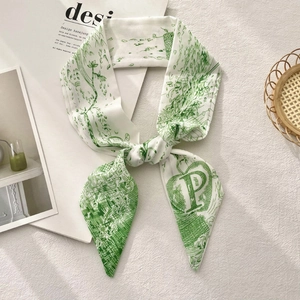 Detail of white twilly silk scarf with green botanical prints and letter P on white texture