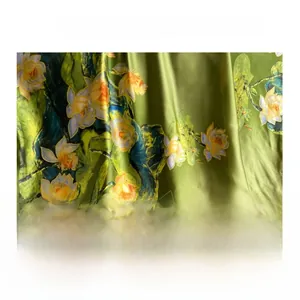 Détail du tissu satiné soyeux avec imprimé lotus traditionnel et drapé fluide doux