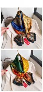 Close-up of luxury silk scarf with gold mandala and tree of life patterns on beige sweater