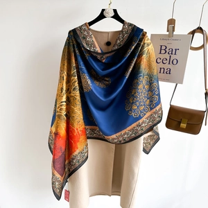 Elegant silk-like scarf with vintage floral print in navy and orange on beige coat