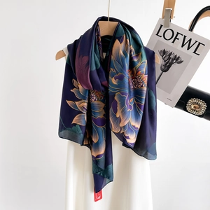 Elegant navy silk long scarf with colorful lotus flower print on a wooden hanger