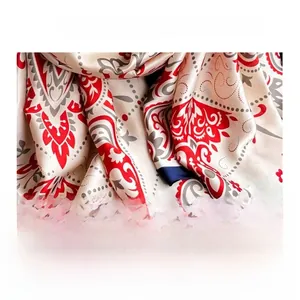 Detailed view of paisley silk satin fabric with elegant drape and navy blue hemmed edges