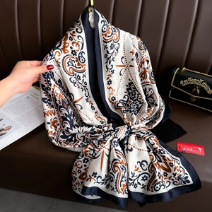 Detail of silk-like scarf featuring vintage paisley floral print and satin texture