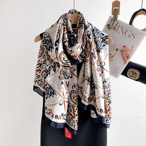Retro paisley print faux silk scarf displayed on a wooden hanger with a stylish black dress