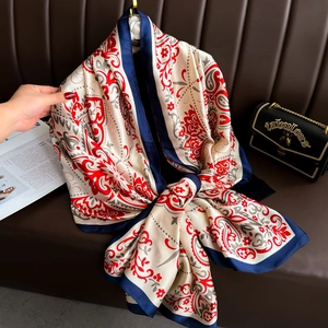 Detail of red paisley silk scarf with vintage floral patterns and smooth satin texture