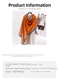 Detail of orange paisley print silk-like scarf featuring premium satin texture and blue border