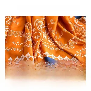 Detailed fabric texture of orange paisley silk scarf showing smooth satin finish