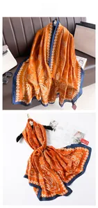 Detail of silk-like long scarf featuring orange paisley prints and navy blue borders