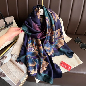Elegant deep purple silk-like scarf featuring blue lotus print over a beige knit sweater
