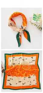 Detail of silk satin square scarf with geometric horse print and green border finish