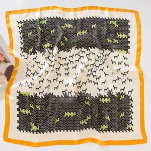 Detail view of square silk scarf with horse patterns and orange rolled edges