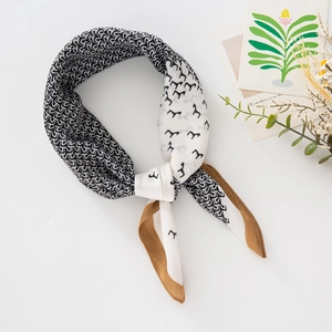 Detail of silk-feel square scarf with geometric wave patterns and bird prints