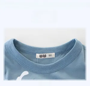Détail de l'encolure du t-shirt bébé bleu clair en coton avec motif mouette et étiquette 90
