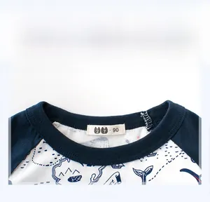 Close-up of navy blue ribbed neckline and whale print on white cotton kids' t-shirt