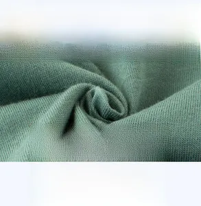 Gros plan sur le tissu en tricot vert respirant pour vêtements doux de bébé