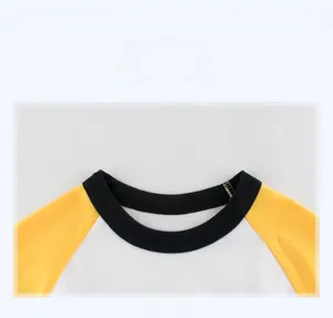 Détail du col rond contrasté sur le t-shirt en coton bicolore jaune et blanc pour garçon