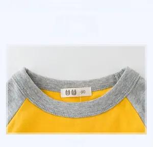Detail of grey ribbed neckline and cotton fabric on yellow raglan sleeve kids' T-shirt