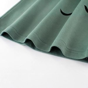 Gros plan d'un t-shirt en tricot vert pour enfant montrant les coutures et le coton doux