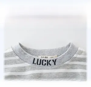 Close-up of ribbed crew neck on striped kids shirt featuring black LUCKY lettering