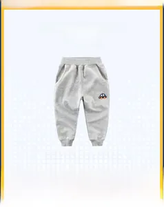 Dettaglio dei pantaloni sportivi grigi per bambini con elastico e ricamo di auto