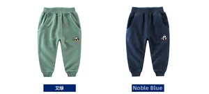 Dettagli dei pantaloni sportivi per bambini in verde salvia e blu navy con ricamo