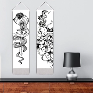 Set of two black and white snake wall scrolls with tassels in a modern living room