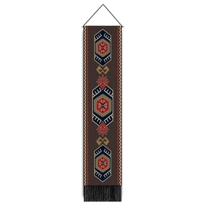 Detail of bohemian wall hanging with tribal geometric patterns and black bottom tassels