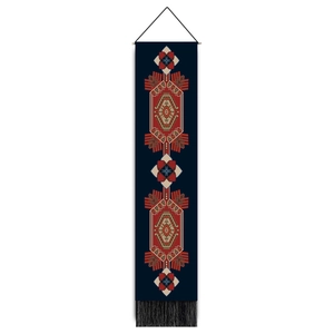 Detail of geometric tribal tapestry with intricate ethnic patterns and black bottom tassels