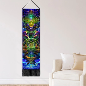 Vertical psychedelic tapestry with vibrant mandala face art and black fringe hanging on a wall